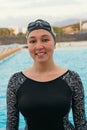 Portrait of competitive female swimmer near swimming pool