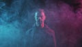Portrait of computer hacker in hoodie. Obscured dark face in neon light. Data thief, internet fraud, darknet and cyber