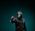 Computer hacker in white mask and hoodie. Obscured dark face. Data thief, internet fraud, darknet and cyber security Royalty Free Stock Photo