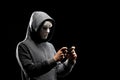 Computer hacker in white mask and hoodie. Obscured dark face. Data thief, internet fraud, darknet and cyber security Royalty Free Stock Photo