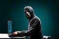 Computer hacker in white mask and hoodie. Obscured dark face. Data thief, internet fraud, darknet and cyber security