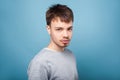 Portrait of concentrated confident brunette man with looking attentively with intelligent serious expression. isolated on blue