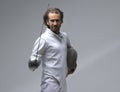 Portrait of concentrated fencer holding his fencing mask in the hand