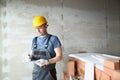 Concentrated male worker hold clipboard and write down needed work material for renovation