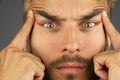 Portrait of concentrated man, lifts eyebrows with fingers, chang Royalty Free Stock Photo