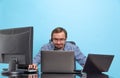 Portrait of concentrated man, programmer, computer system analyst working with operating sytem isolated over blue Royalty Free Stock Photo