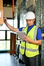 Concentrated Asian male warehouse worker using tablet to check and manage his inventory Royalty Free Stock Photo