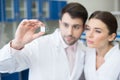 Portrait of concentrated scientists looking at microscope slide