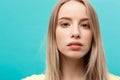 Portrait Concept: face of a beautiful young girl with a clean fresh face close up. over blue background. Royalty Free Stock Photo