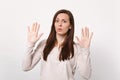 Portrait of concerned perplexed young woman in light clothes showing palms, rising hands isolated on white wall