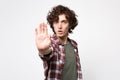 Portrait of concerned young man in casual clothes looking camera, showing stop gesture with palm isolated on white Royalty Free Stock Photo