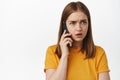 Portrait of concerned young woman listening with worried face, receive alarming phone call, talking on smartphone Royalty Free Stock Photo