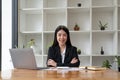 Portrait confidence asian business woman looking on camera sitting at work desk in office.