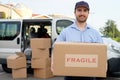 Portrait of confidence express courier next to his delivery van Royalty Free Stock Photo