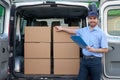 Portrait of confidence express courier next to his delivery van Royalty Free Stock Photo