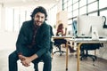 Portrait, confidence and happy man in chair at coworking space, ideas for project and entrepreneur at design agency