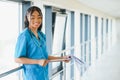 Portrait confident African American female doctor medical professional writing patient notes isolated on hospital clinic hallway