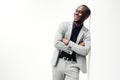 Confident african american man leaning against white wall in business suit and arms crossed Royalty Free Stock Photo