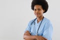 Portrait of confident african american mid adult female doctor against white background, copy space Royalty Free Stock Photo