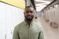 Portrait of confident african american young male teacher standing in school corridor Royalty Free Stock Photo