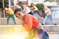 African boy dancing hip-hop with group of tweens on city street
