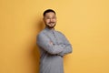 Portrait of confident asian man standing with folded arms on yellow background Royalty Free Stock Photo