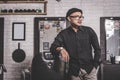 Portrait of confident barber man at barbershop standing at chair