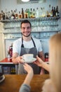 Portrait of confident barista serving coffee to customer at cafe Royalty Free Stock Photo