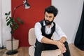 Portrait of confident bearded business man wearing elegant formalwear sitting on chair with crossed arms, serious Royalty Free Stock Photo