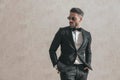 Confident bearded fashion man in elegant suit holding hands in pockets Royalty Free Stock Photo