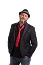 Portrait of confident bearded man with black suit, red tie and hat. People, style and fashion concept.