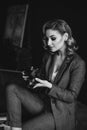 Portrait of a confident beautiful business woman in a suit on a dark background holds a camera in her hands. The concept of gender Royalty Free Stock Photo