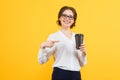 Portrait of confident beautiful young smiling happy business woman showing on cup of coffee with her hand on yellow Royalty Free Stock Photo