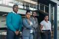 Portrait of a confident black businesswoman crossing her arms with all african team in the background Royalty Free Stock Photo