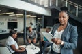 Portrait of a confident black African businesswoman using her tablet looking into the camera