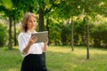 Portrait of confident business girl looking at the camera. Businesswoman holds digital tablet in hand, stern look Royalty Free Stock Photo