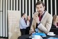 Portrait of confident businessman holding smart phone during coffee break in convention center Royalty Free Stock Photo