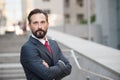 Portrait of confident businessman looking at you with his arms crossed