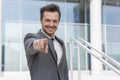 Portrait of confident businessman pointing at you outside office building Royalty Free Stock Photo