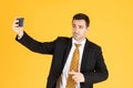 Portrait of confident businessman using smartphone to take selfie