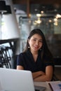 Confident businesswoman sitting at office desk and smiling to camera. Royalty Free Stock Photo