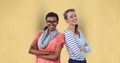 Portrait of confident businesswomen standing arms crossed against yellow background