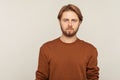 Portrait of confident calm handsome man with neat hair and beard wearing sweatshirt standing, looking at camera