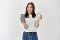 Portrait of a confident casual girl holding blank screen mobile phone and showing credit card isolated over white Royalty Free Stock Photo