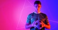 Portrait of confident caucasian athlete holding soccer ball with geometric neon design, copy space
