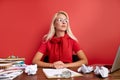 Portrait of confident caucasian blonde female sitting at office desk with laptop and papers Royalty Free Stock Photo