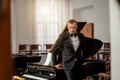 Portrait of confident caucasian male musician near piano