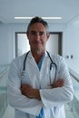 Male surgeon standing with arms crossed in the corridor in hospital Royalty Free Stock Photo