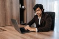 Portrait of confident CEO wearing suit working on laptop computer sitting at office desk. Successful businessman with Royalty Free Stock Photo