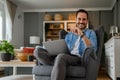 Portrait of confident cheerful male freelancer holding laptop and sitting with laptop on armchair in home office Smiling young Royalty Free Stock Photo